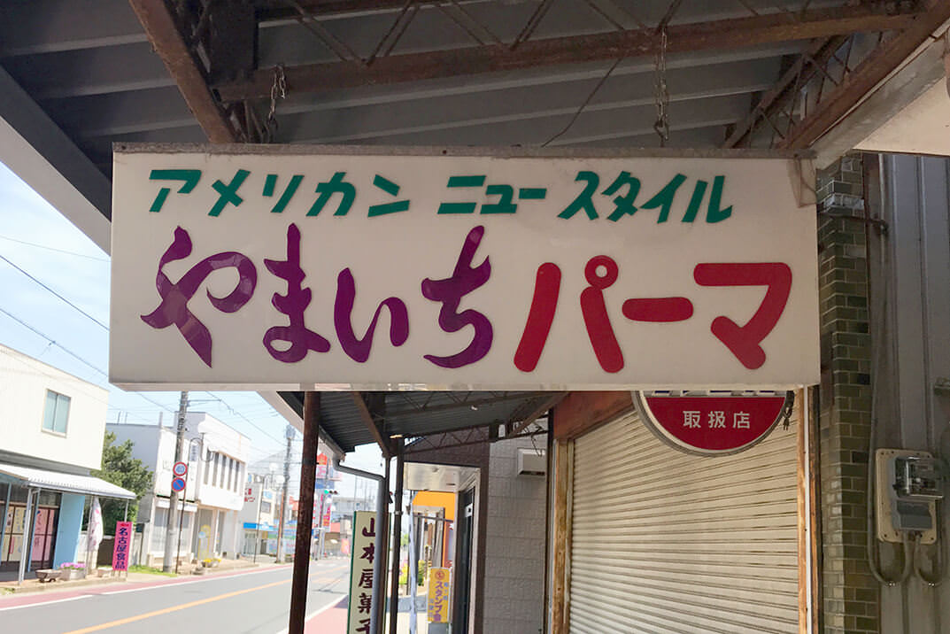 アメリカン　ニュースタイル　やまいちパーマ　と書かれた看板