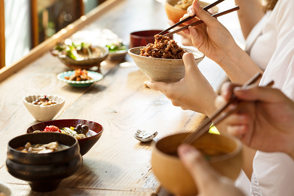 玄米ごはんのある食卓でごはんを食べる人たちのイメージ