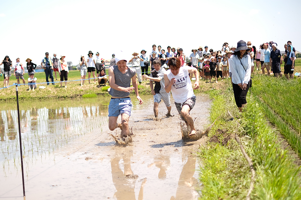 田んぼを全力疾走する大人たち